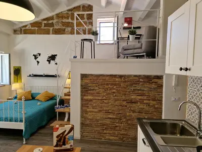 a living room with a bed and a brick wall at Il Fico d'India by Holiday World in Palermo