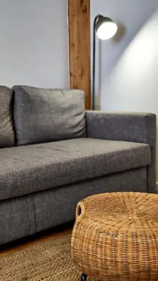 a living room with a couch and a ottoman at Disìu Apartment con Jacuzzi in centro a Castellammare del Golfo in Scopello