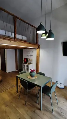 a dining room with a green table and chairs at Disìu Apartment con Jacuzzi in centro a Castellammare del Golfo in Scopello