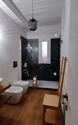a bathroom with two white toilets and a green wall at Disìu Apartment con Jacuzzi in centro a Castellammare del Golfo in Scopello