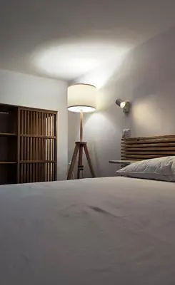 a bedroom with a white bed and a lamp at Disìu Apartment con Jacuzzi in centro a Castellammare del Golfo in Scopello