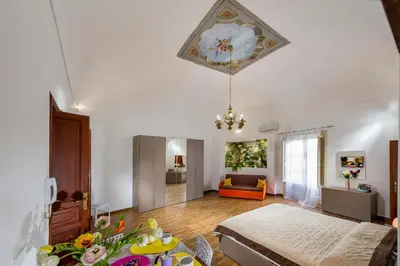 a room with a bed and a table with flowers on it at Oasi del Libro in Castellammare del Golfo