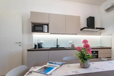 a kitchen with a table with a vase of flowers on it at Villa Giunella in San Vito lo Capo
