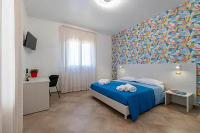 a bedroom with a blue bed with towels on it at Villa Giunella in San Vito lo Capo