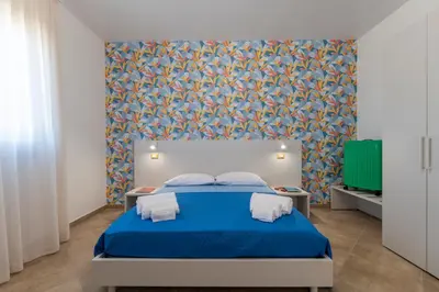 a bedroom with a blue bed with a blue blanket at Villa Giunella in San Vito lo Capo