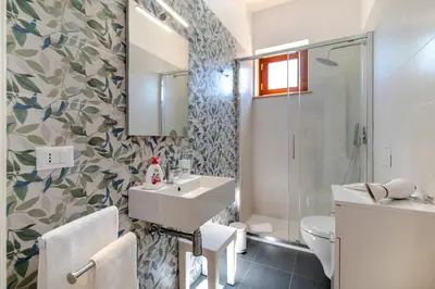 a bathroom with a sink and a toilet and a shower at Villa Giunella in San Vito lo Capo