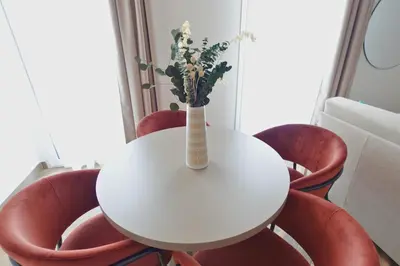 a white table with red chairs and a vase with flowers at Eccelso Case Vacanza in Palermo