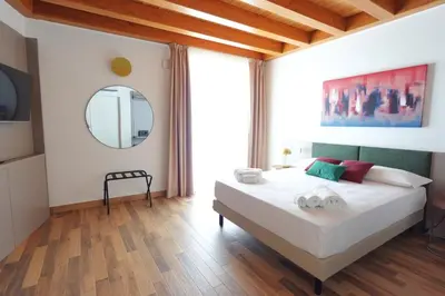 a bedroom with a large white bed with a mirror at Eccelso Case Vacanza in Palermo