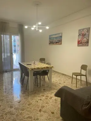 a dining room with a table and chairs in a room at Il Sole di Palermo in Palermo