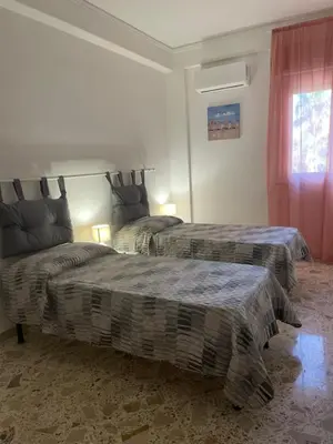 a bedroom with two beds and a window at Il Sole di Palermo in Palermo