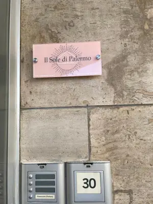 a sign on the side of a stone wall at Il Sole di Palermo in Palermo