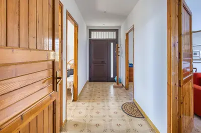a hallway with wooden doors and a floor with a carpet at Villa Mare Blu in Ficarazzi