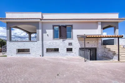 a white brick house with a gate in front of it at Villa Mare Blu in Ficarazzi