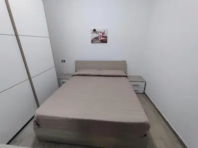 a bedroom with a bed with a dresser and a mirror at Cinque Raggi di Sole in Isola delle Femmine