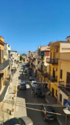 an empty street with a building with a balcony at Cinque Raggi di Sole in Isola delle Femmine