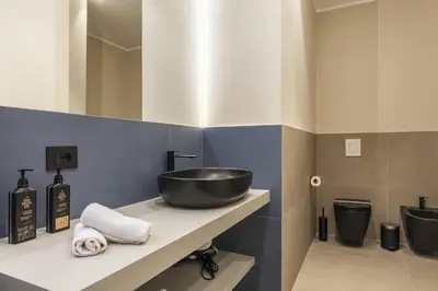 a bathroom with a sink and two toilets at Lolli Boutique & SPA Mondello in Palermo