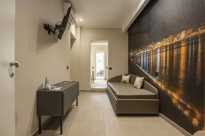 a living room with a couch and a painting on the wall at Lolli Boutique & SPA Mondello in Palermo