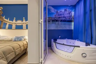 a bedroom with a bath tub next to a bed at Lolli Boutique & SPA Mondello in Palermo