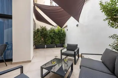 a patio with a glass coffee table and chairs at Lolli Boutique & SPA Mondello in Palermo