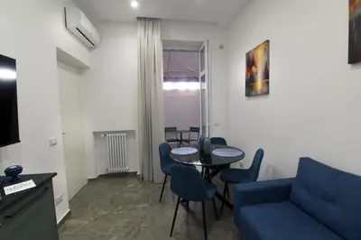 a living room with a couch and a table and chairs at Fervore Luxury Rooms-Apartments in Palermo