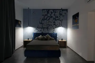 a bedroom with a blue bed with two tables at Fervore Luxury Rooms-Apartments in Palermo