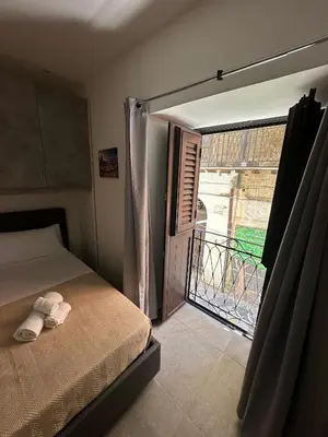 a bedroom with a bed and a door to a balcony at A casa di Maria in Palermo