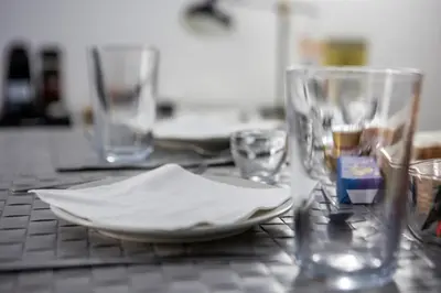 a table with a plate and glasses on it at Palermo al Centro - Appartamento Fiume in Palermo