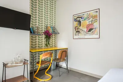 a room with a table and two chairs and a wall at Cassaro261 in Palermo