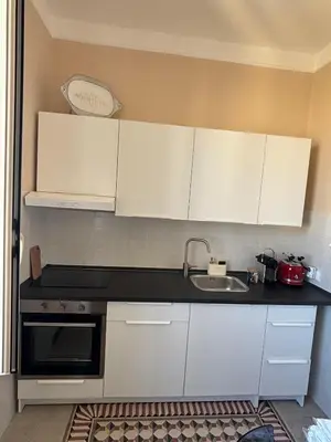 a kitchen with white cabinets and a sink at Le Lunette Holiday House in Palermo