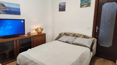 a living room with a couch and a tv and a chair at La casetta di Totò in Palermo