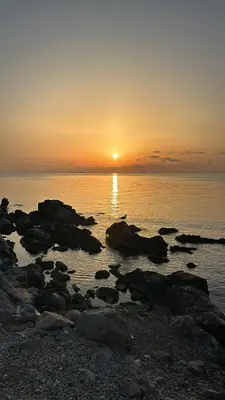 a sunset over a body of water with rocks at La casetta di Totò in Palermo