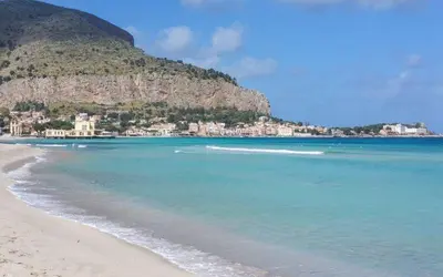 a view of a beach with a mountain in the background at La casetta di Totò in Palermo