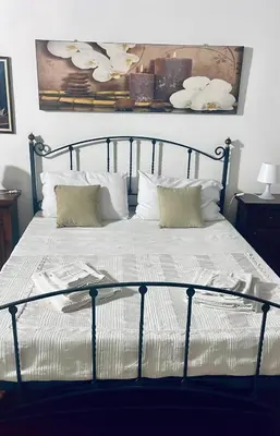 a bed with white pillows and a picture on the wall at La Suite nel Centro di Palermo in Palermo