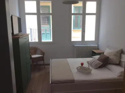 a bedroom with a bed with a television and two windows at Home In City in Palermo