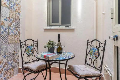 a table with two chairs and a table with a wine glass at Antony Mondello Guest House, appartamento a 1 minuto a piedi dalla spiaggia di Mondello in Palermo