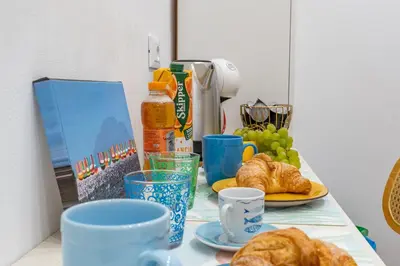 a table topped with cups and croissants on a table at Antony Mondello Guest House, appartamento a 1 minuto a piedi dalla spiaggia di Mondello in Palermo