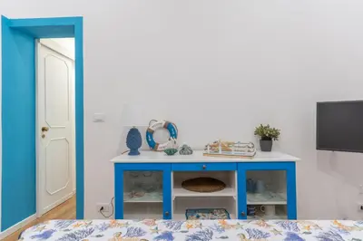 a blue table in a room with a tv at Antony Mondello Guest House, appartamento a 1 minuto a piedi dalla spiaggia di Mondello in Palermo