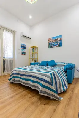 a bedroom with a bed with a striped blanket at Antony Mondello Guest House, appartamento a 1 minuto a piedi dalla spiaggia di Mondello in Palermo
