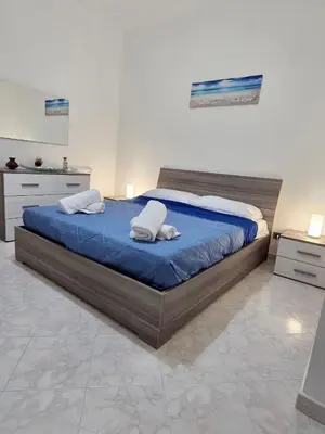 a bedroom with a large bed with two pillows on it at Casa Pino in Isola delle Femmine