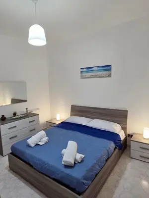 a bedroom with a large blue bed with two pillows at Casa Pino in Isola delle Femmine