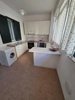 a kitchen with white cabinets and a washer and dryer at Casa Pino in Isola delle Femmine