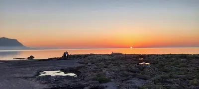 a person standing on the beach at sunset at Casa Pino in Isola delle Femmine