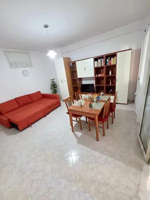 a living room with a red couch and a table at Casa Pino in Isola delle Femmine