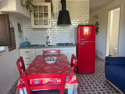 a kitchen with a red table and a red refrigerator at Vista mare 360 in Scopello