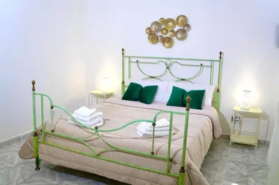 a bedroom with a green and white bed with green pillows at Chic Angolo di Anita in Palermo