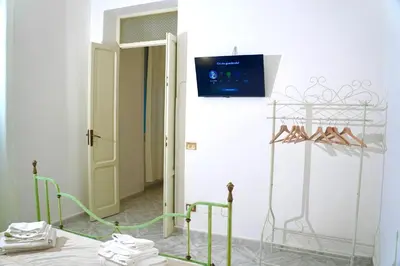 a room with a tv on the wall and shoes at Chic Angolo di Anita in Palermo