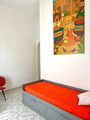 a bed in a room with a poster on the wall at Chic Angolo di Anita in Palermo
