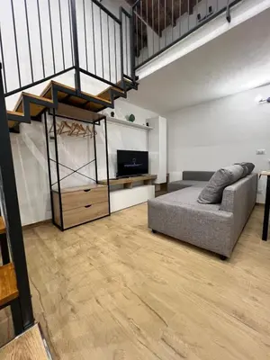 a living room with a couch and a tv and stairs at Kiccifù home in Palermo