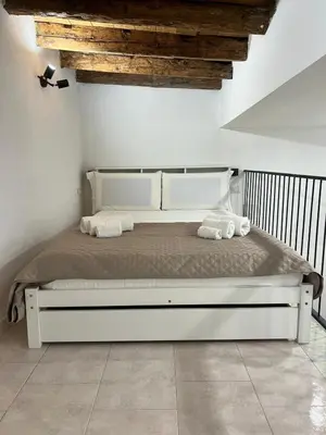 a white bed with two towels on it in a bedroom at Kiccifù home in Palermo