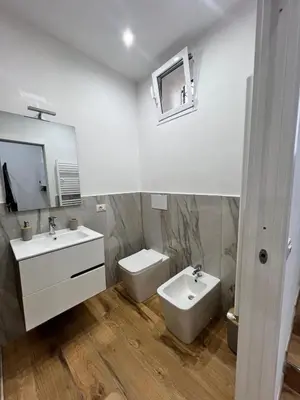 a white bathroom with a sink and a toilet at Kiccifù home in Palermo